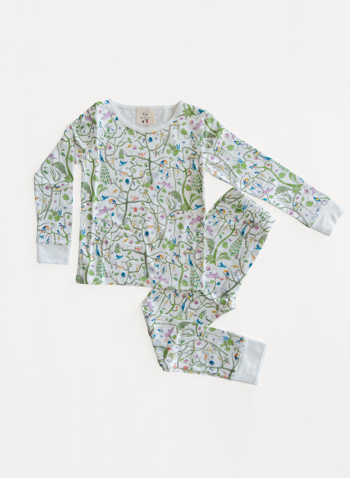 A two-piece children's pajama set featuring a long-sleeve top and matching pants with an all-over whimsical print of birds, flowers, and leaves on a white background. The set is laid flat on a clean, light off-white background.