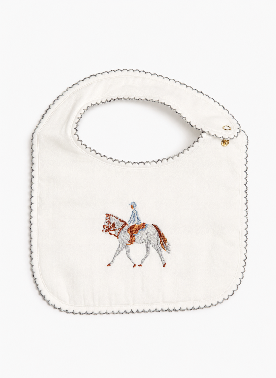 An off-white cotton baby bib with scalloped edges, featuring an embroidered illustration of a horse and rider in the center.