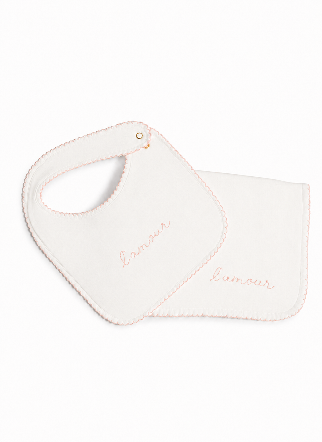 A white baby bib with a matching square cloth, both featuring the word 'l'amour' embroidered in light pink script, set against a plain white background.