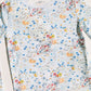 A children's long-sleeve top by Timo & Violet, featuring a colorful space-themed print with rockets, planets, stars, and suns on a pale blue background.