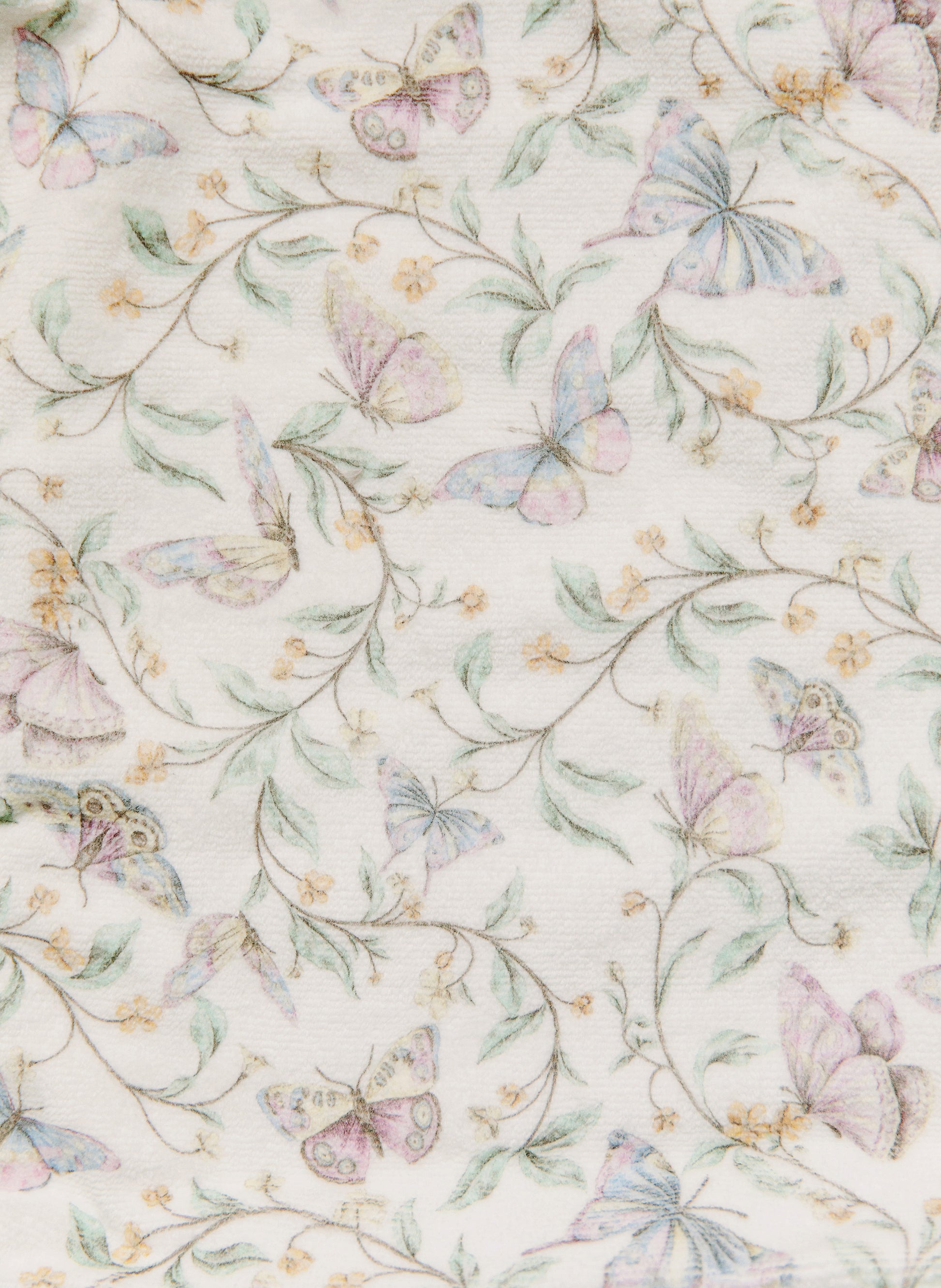 A close-up of a fabric or wallpaper pattern featuring delicate pastel butterflies in pink, lavender, and blue, interspersed with soft green leaves and thin stems on an off-white background.