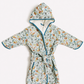 A hooded cotton robe with a colorful floral and botanical print, featuring teal blue piping and a matching tie belt, laid flat against a light off-white background.