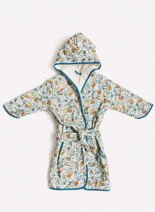 A hooded cotton robe with a colorful floral and botanical print, featuring teal blue piping and a matching tie belt, laid flat against a light off-white background.