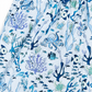 Close-up of a pair of shorts with an all-over underwater print featuring octopuses, fish, sea corals, and sea turtles in shades of blue, navy, and light green on a white background.