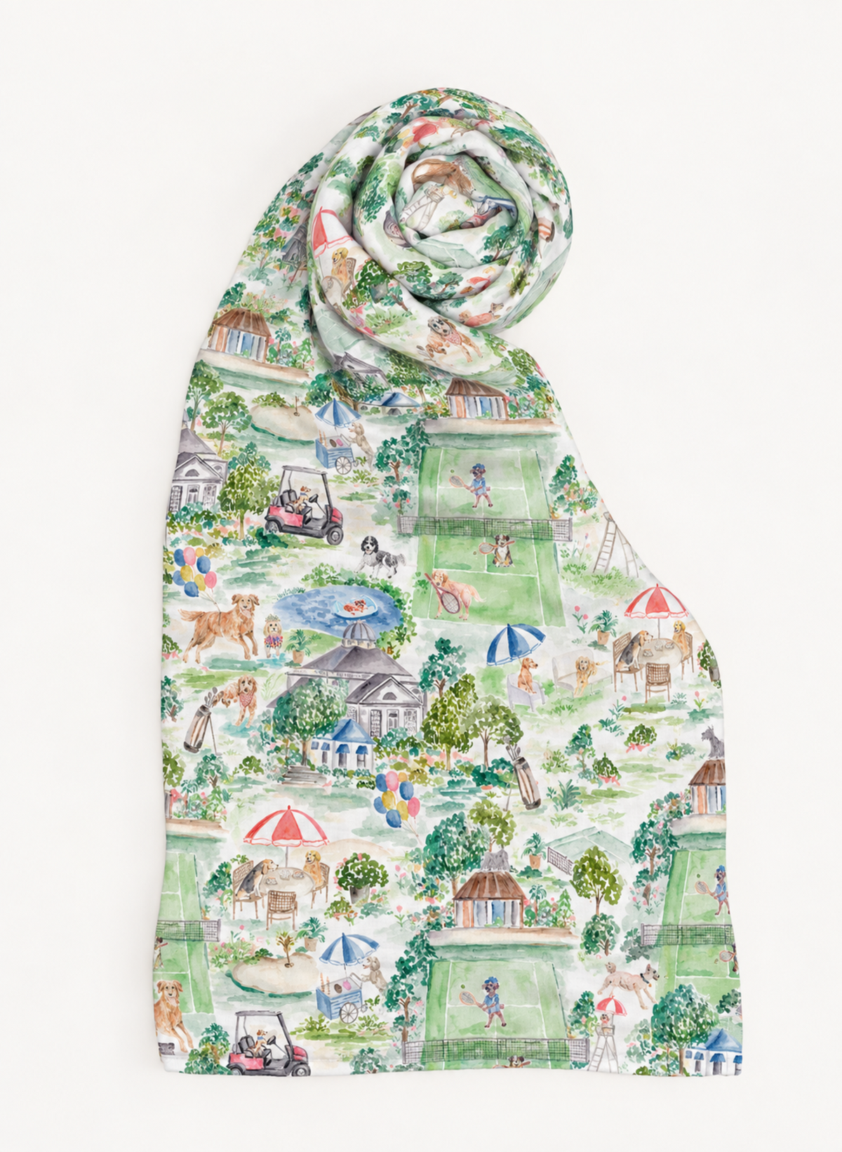 A lightweight scarf with a detailed, whimsical toile-style print featuring golf course scenes, dogs, people, umbrellas, and houses in soft green, beige, and blue tones, rolled at the top against a plain white background.