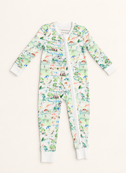 A baby long-sleeve footless zip-up one-piece pajama with an all-over illustrated print in pastel green, blue, pink, and orange on a white base, shown flat against a light cream background.