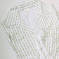 White robe with green floral pattern on a light gray background
