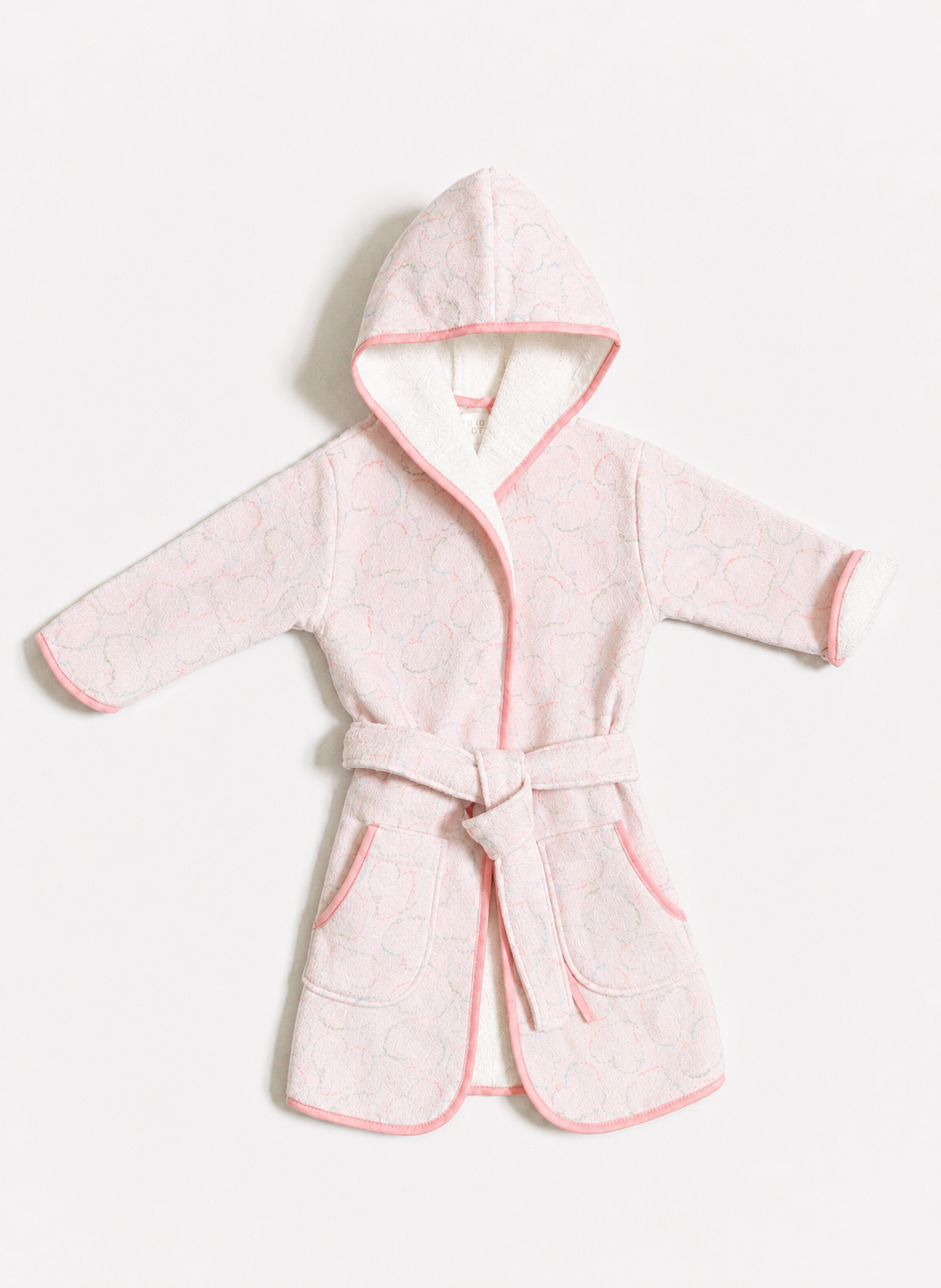 A light pink hooded bathrobe with a matching tie belt, featuring a subtle tonal pattern, pink piping, and a white inner lining, displayed flat against a light gray background.