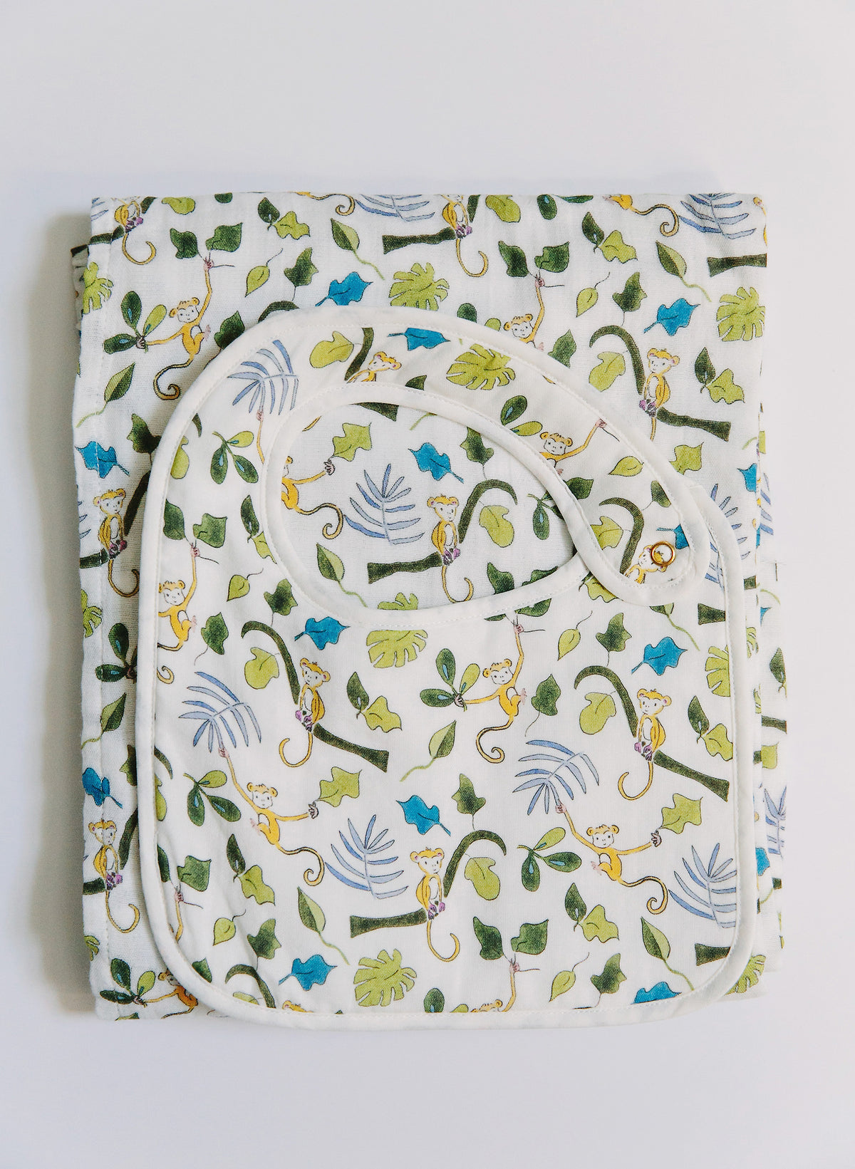 Baby blanket with monkey and leaf pattern on a white background