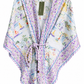 A lightweight wrap kimono with a lavender and blue floral border and a multicolor toile-style print featuring sailboats and figures on a white background, shown hanging on a white hanger.