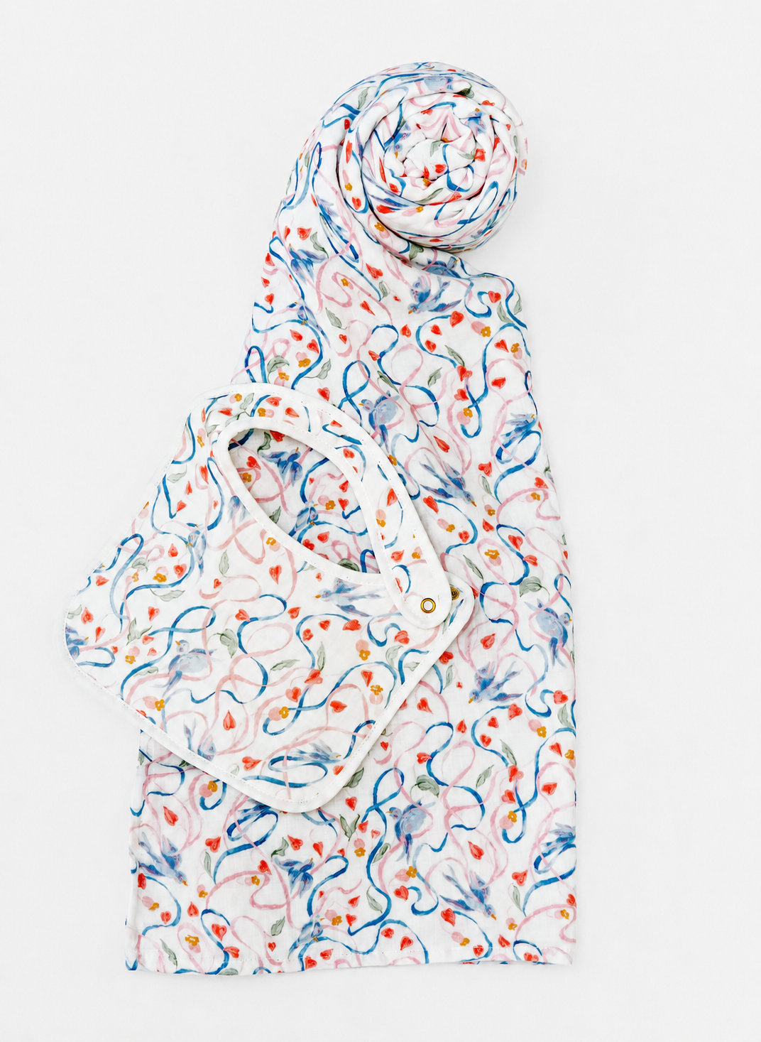A white baby wrap or burp cloth with a colorful abstract pattern of blue, orange, and yellow swirls, folded and rolled on a light gray background.