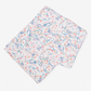 A folded white scarf featuring a delicate, hand-drawn style abstract pattern in light blue, pink, and orange, displayed on a clean white background.