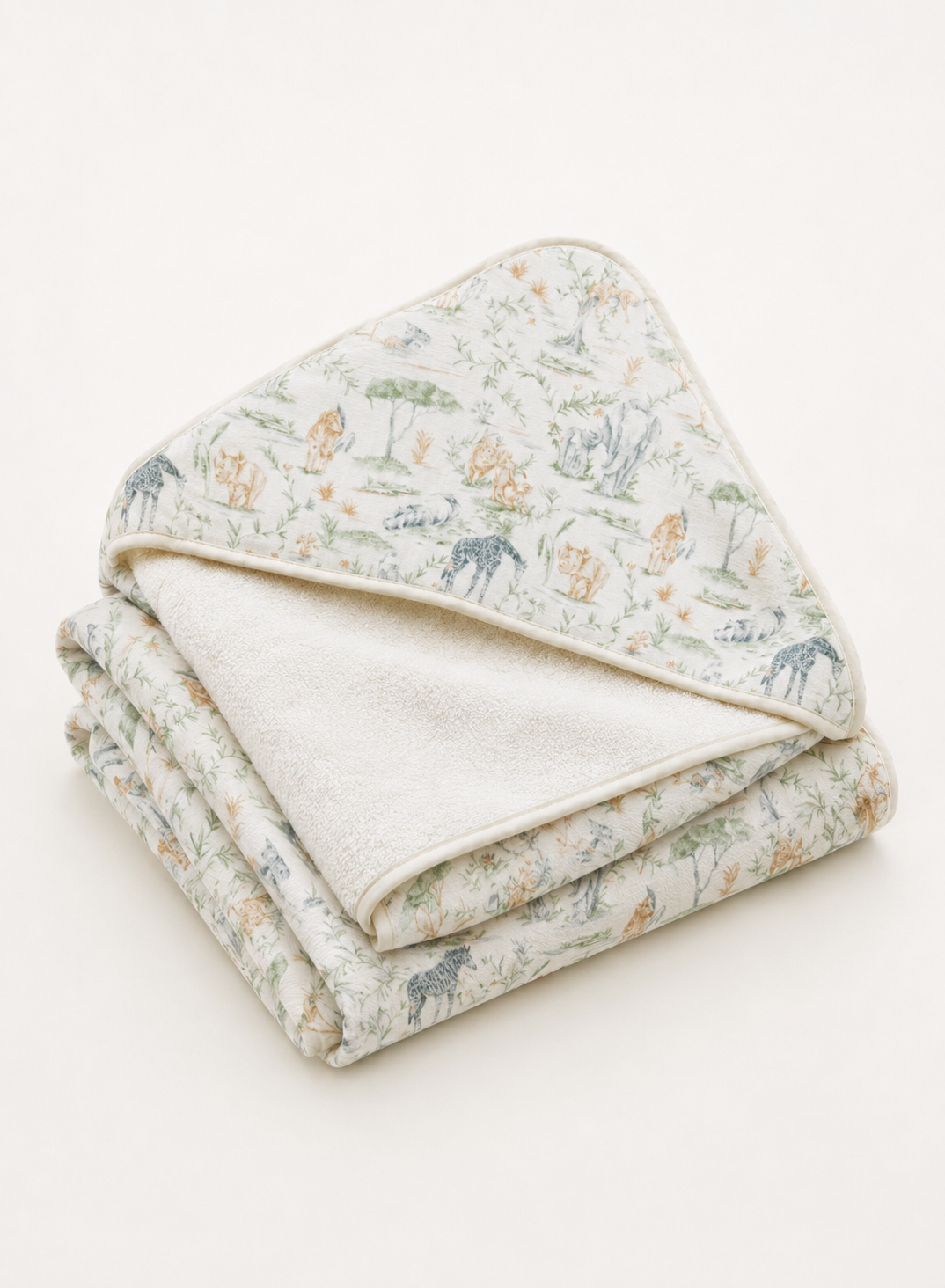 A folded baby blanket with a soft, textured off-white reverse side and a printed front side featuring a safari animal pattern in muted green, blue, and beige tones, set against a plain off-white background.