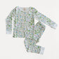 A two-piece children's pajama set featuring a long-sleeve top and matching pants with an all-over whimsical print of birds, flowers, and leaves on a white background. The set is laid flat on a clean, light off-white background.