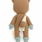 A knitted plush toy shaped like a fox, shown from the back on a plain white background. The body is a warm camel brown, with a cream-colored tail, light blue-green paw cuffs, and matching light blue-green paws.