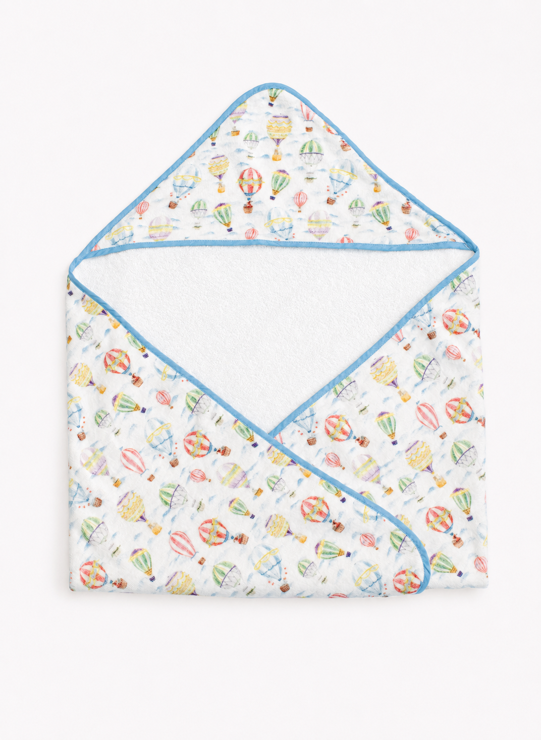 A baby hooded towel with a white background and a colorful hot air balloon pattern, finished with light blue trim.