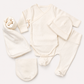 A five-piece baby clothing set in a soft cream or off-white color, including a long-sleeve wrap bodysuit, footed pants, a beanie, a hat, and a bootie, arranged neatly on a light beige background.