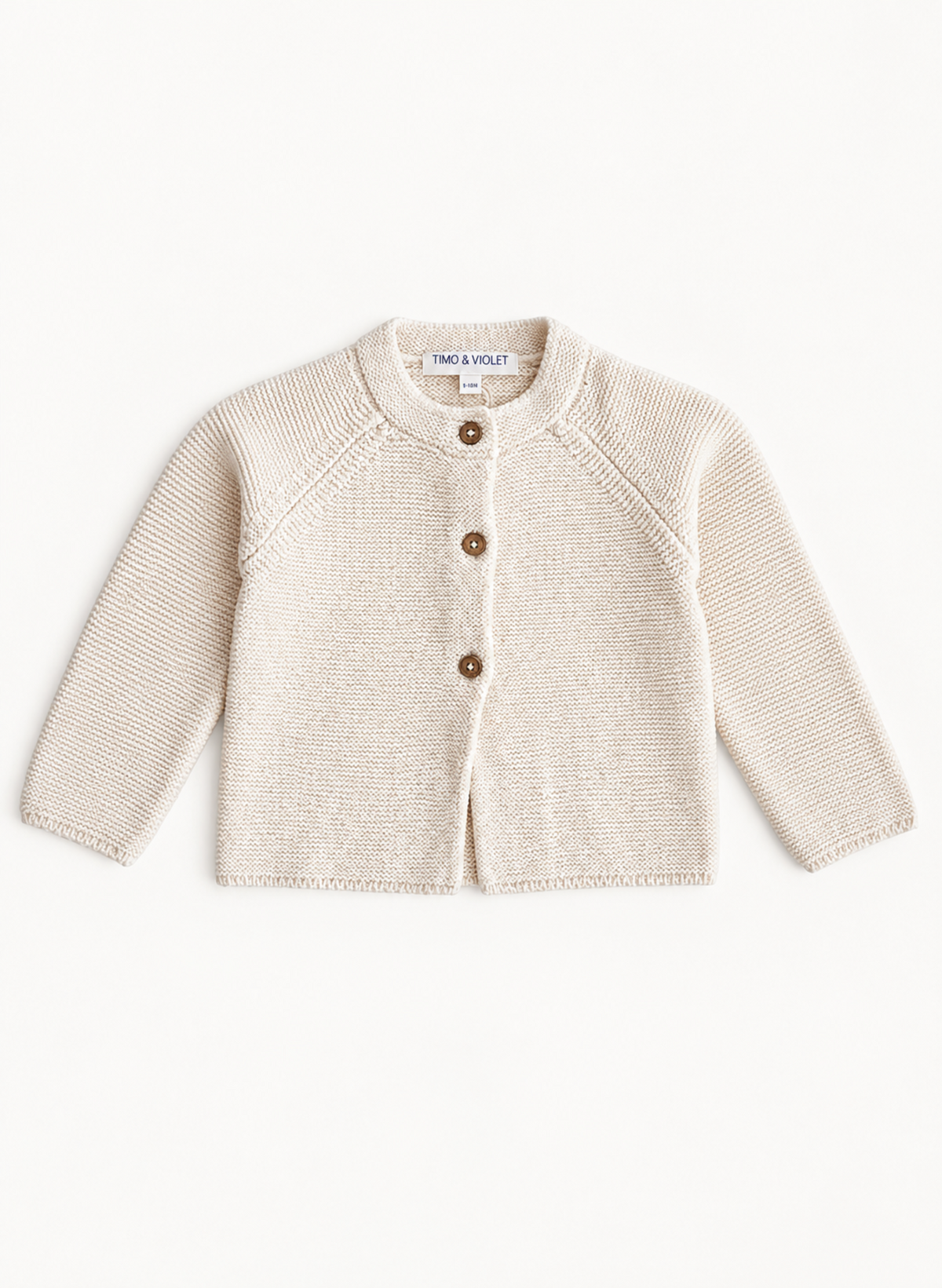 A cream-colored knit cardigan sweater for toddlers, featuring a round neck, raglan sleeves, and three brown buttons down the front. The brand name 'TMC & VLOT' is visible on the inner neck label.